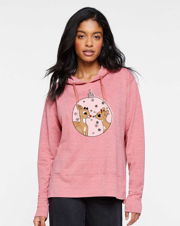 A woman wearing a pink hoodie with a graphic of two cartoon reindeer on it.