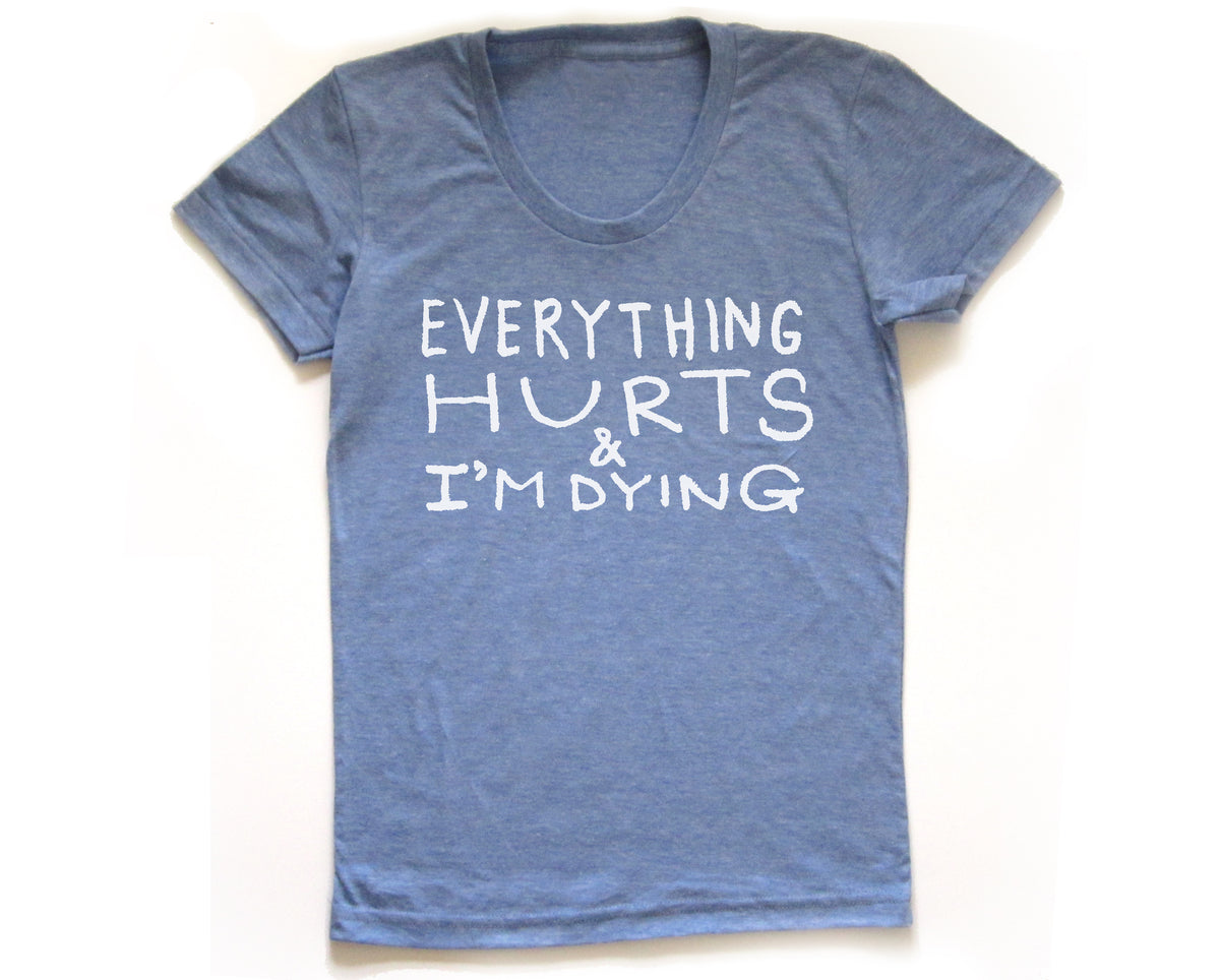 A blue t-shirt with white text that reads "EVERYTHING HURTS & I'M DYING".