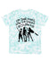A light blue tie-dye t-shirt with a graphic design featuring silhouettes of three people and text that reads "I'm done hiding now I'm shining like I'm born to be".