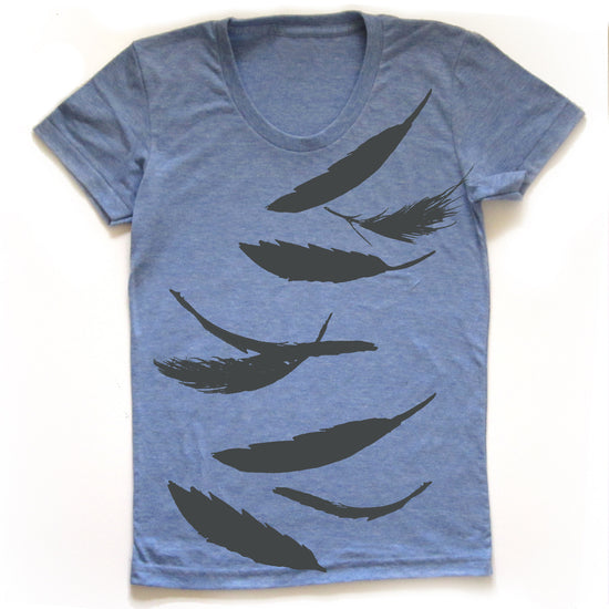 A blue t-shirt with a graphic design of black silhouettes of feathers.