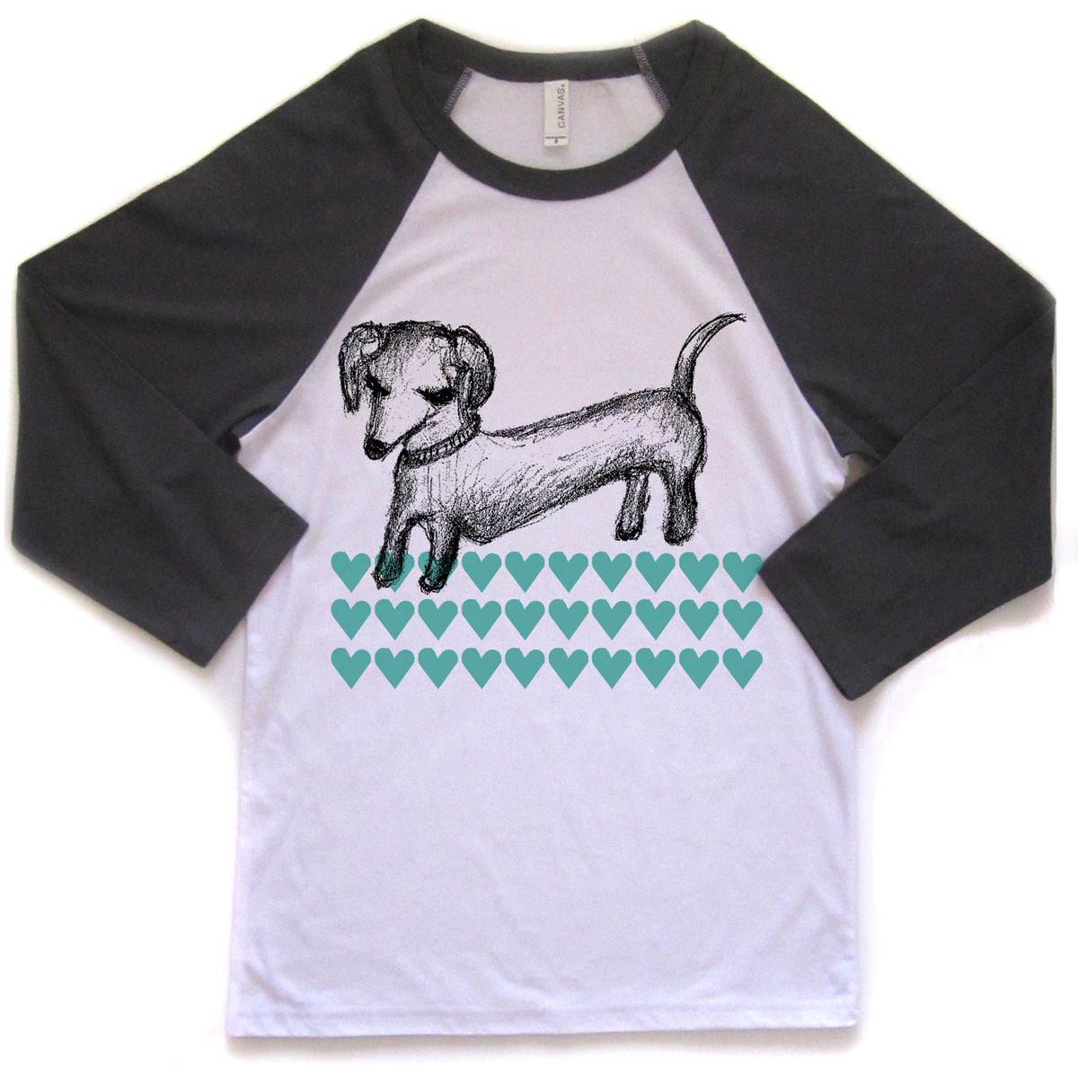 A white and black baseball-style t-shirt with a graphic design of a dachshund dog and a pattern of green hearts.