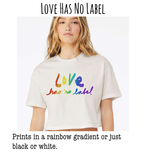 A young woman wearing a white t-shirt with a rainbow gradient design and the text "Love Has No Label" printed on it.