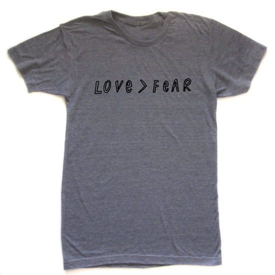 A gray t-shirt with the text "LOVE > FEAR" printed on it.