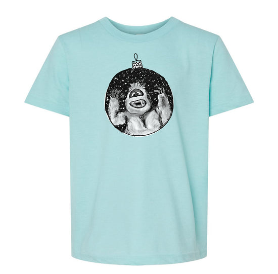 A light blue t-shirt with a graphic design depicting a monster or monster-like creature inside a circular ornament.