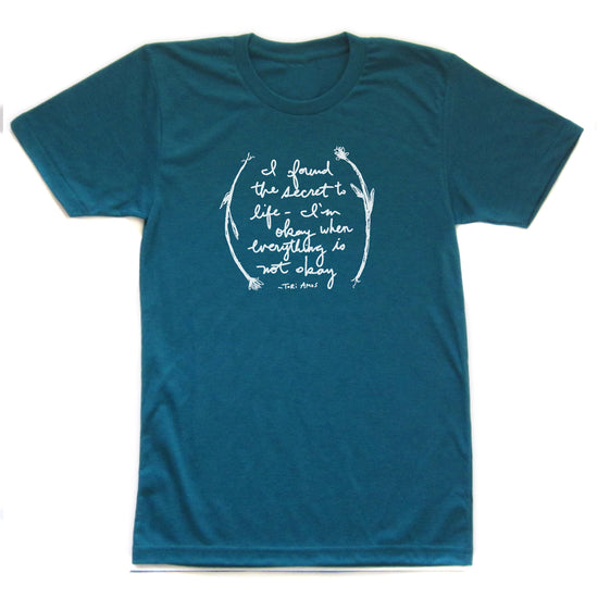 A teal-colored t-shirt with a white text design that reads "I found the secret to life is getting angry when everything is not okay".