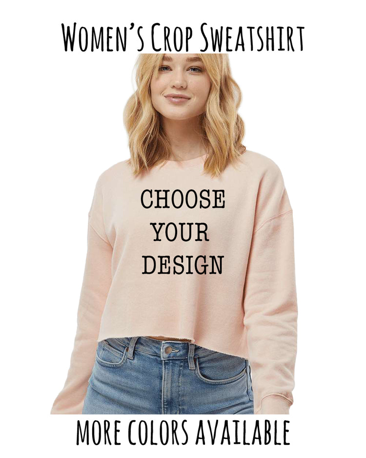 A woman wearing a pink crop sweater with the text "CHOOSE YOUR DESIGN" printed on it, standing against a white background.