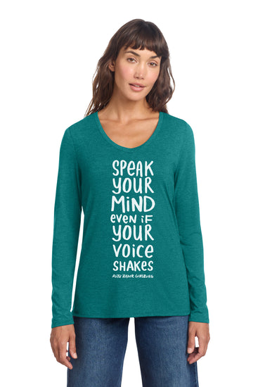 A woman wearing a teal long-sleeved shirt with a motivational quote printed on it.