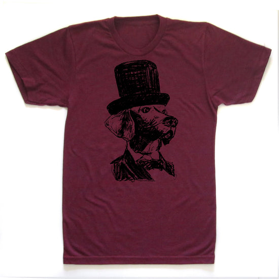 A burgundy-colored t-shirt with a black and white illustration of a dog wearing a top hat.