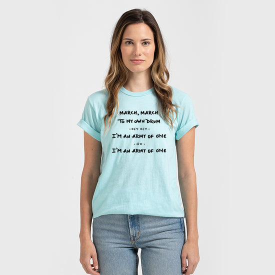 A woman wearing a light blue t-shirt with text printed on it.