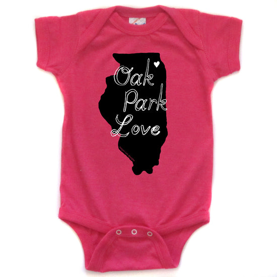 A pink baby onesie with a black outline of the state of Illinois and the text "OAK PARK LOVE" printed on it.