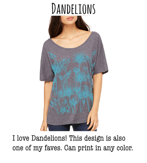 A woman wearing a gray t-shirt with a blue floral design, posing for a photograph.