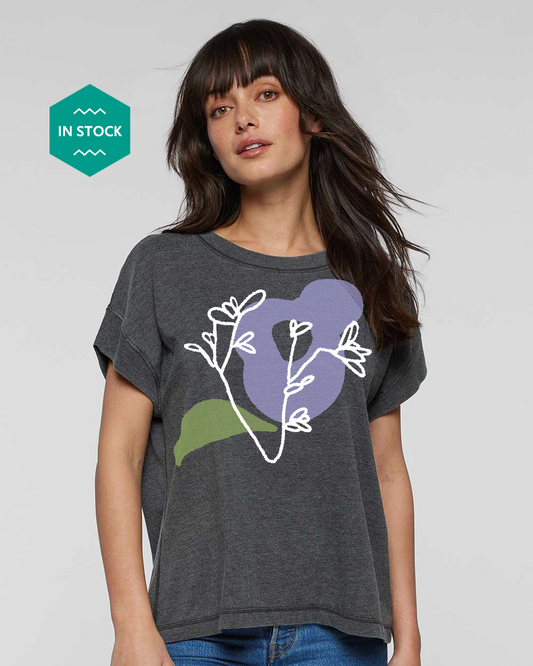 a woman wearing a t - shirt with a flower on it