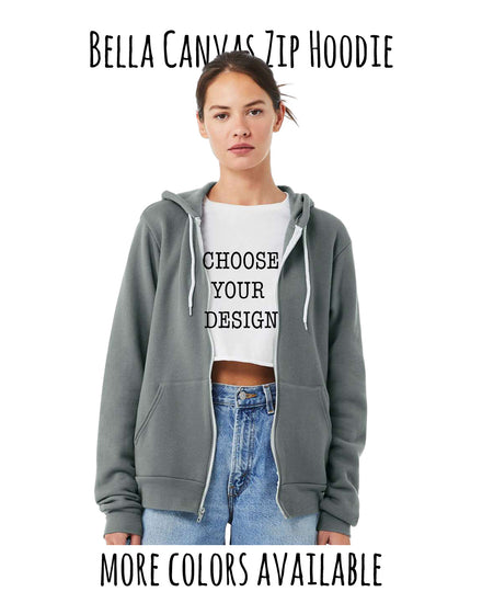 A woman wearing a gray zip-up hoodie with a white t-shirt that says "Choose your design" and jeans.