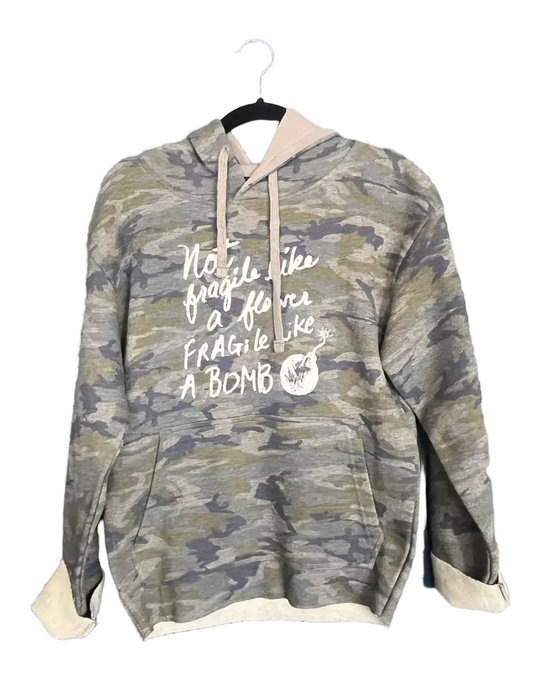 A camouflage hoodie with the text "Not fragile like a bomb" printed on it.