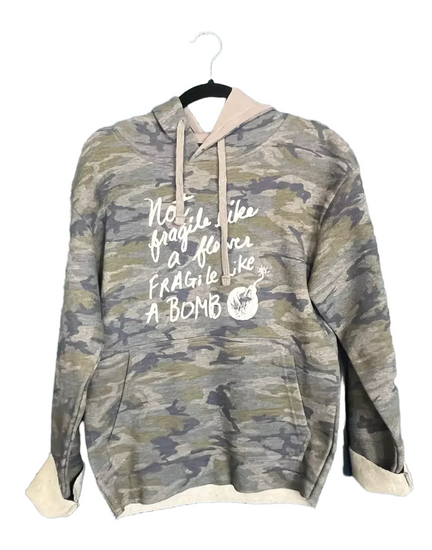 A camouflage hoodie with the text "Not fragile like a bomb" printed on it.