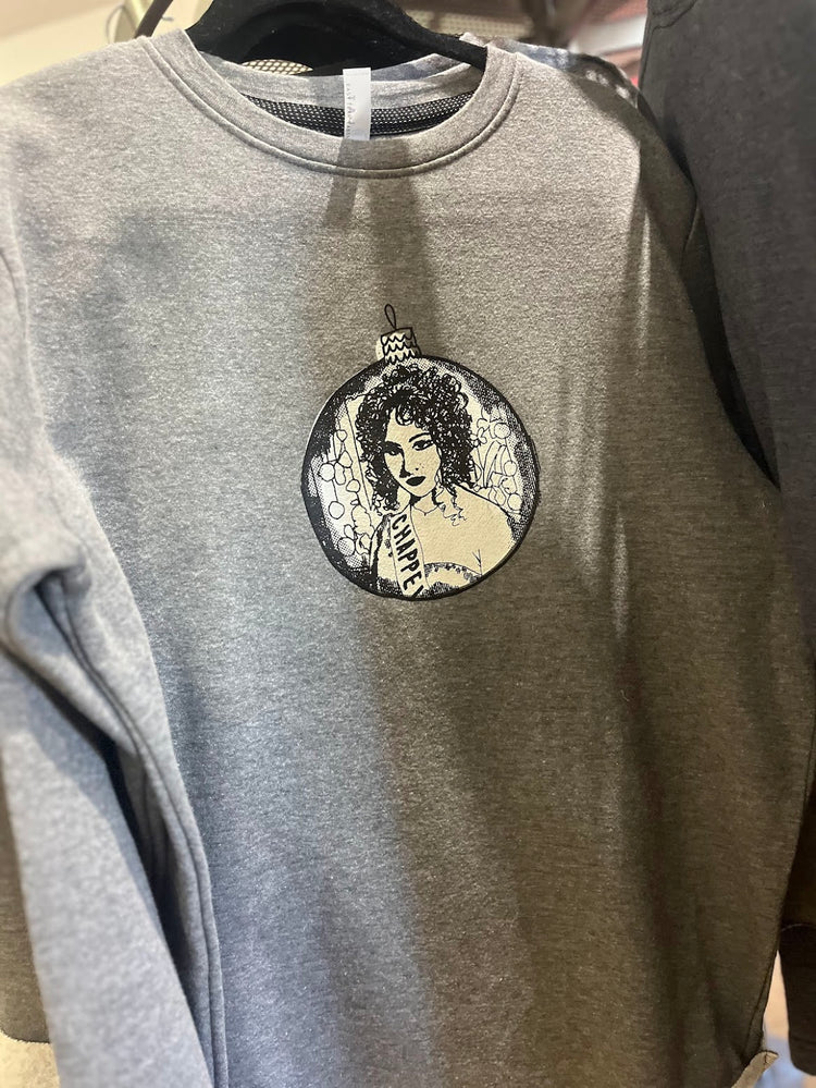 A gray sweatshirt with a circular design featuring a woman's face and the text "VAMPIRES" printed on it.