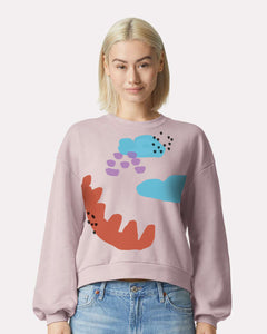 a woman wearing a pink sweatshirt with an image of a dinosaur on it