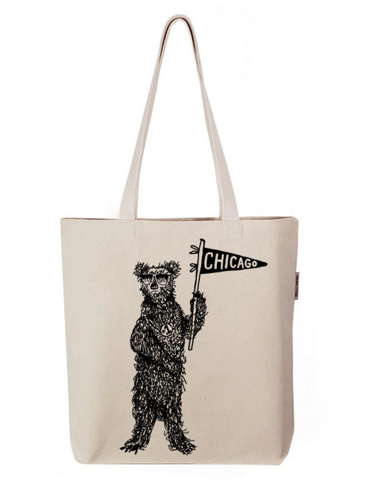 a tote bag with a bear holding a sign